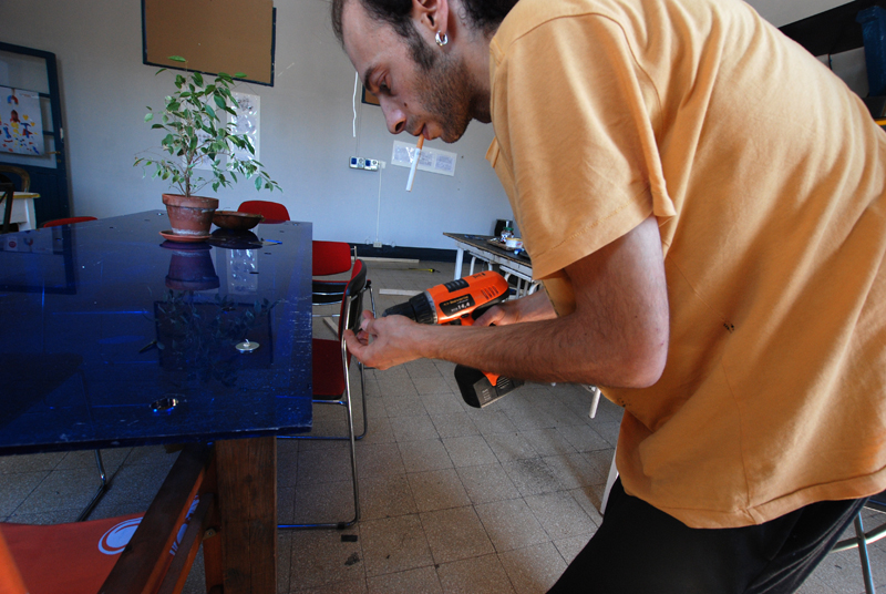 Massimiliano alle prese con un tavolo. Pittore e artista, al coworking fa mostre in cambio di lavori di manutenzione